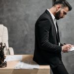 Advogado de fato preto analisa documentos numa mesa de escritório.
