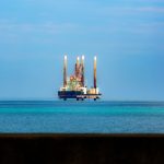 Plataforma de petróleo distante em alto-mar sob céu claro